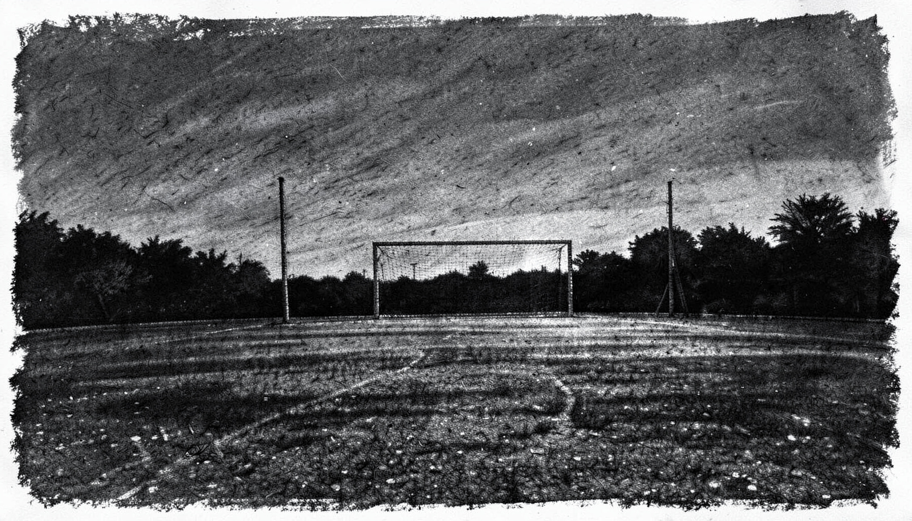 A bold charcoal drawing of a wide sports field at dusk, with faint goalposts silhouetted against a deep gray sky, conveying quiet dedication and community spirit.